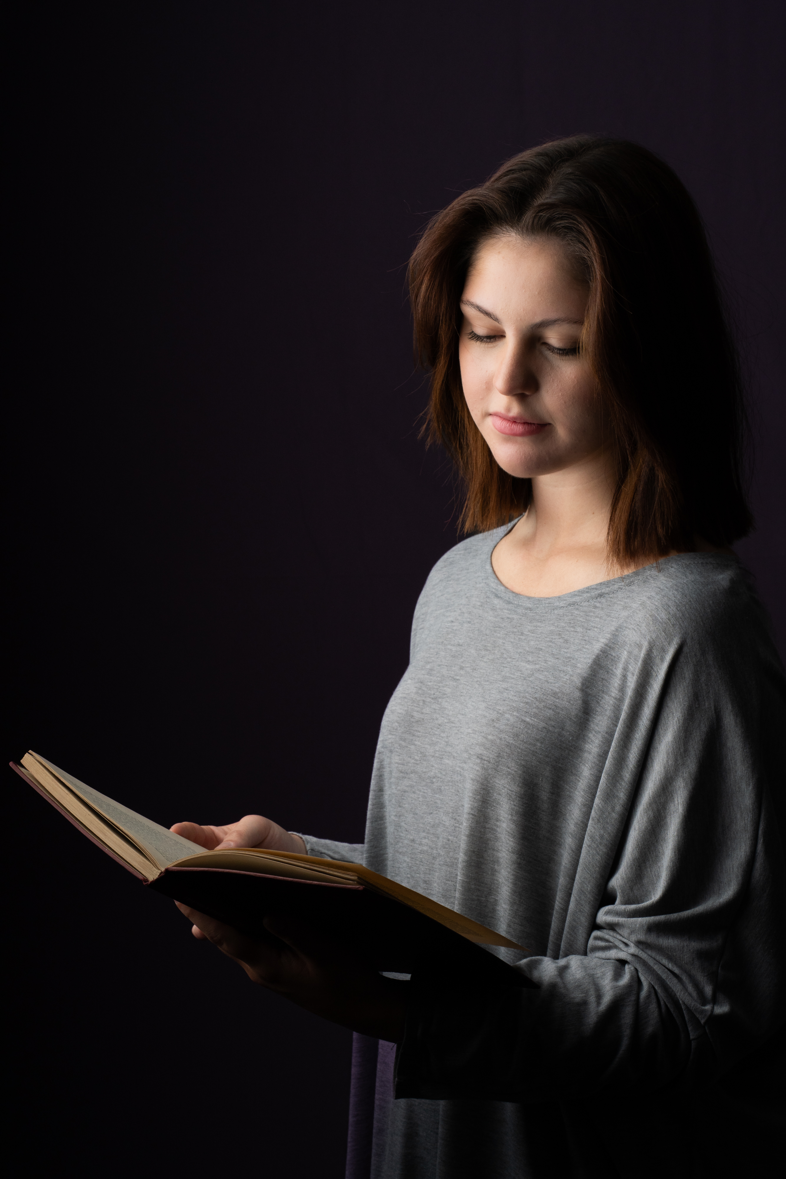 Thoughtful studio portrait of a woman reading